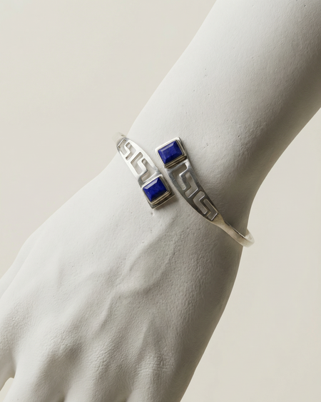 Silver bracelet with blue stones on a white hand