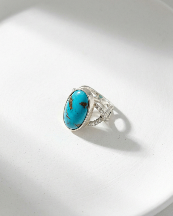 Silver ring with a turquoise stone on a white background
