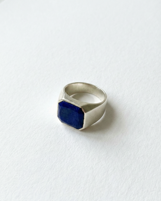Silver ring with a blue stone on a white background