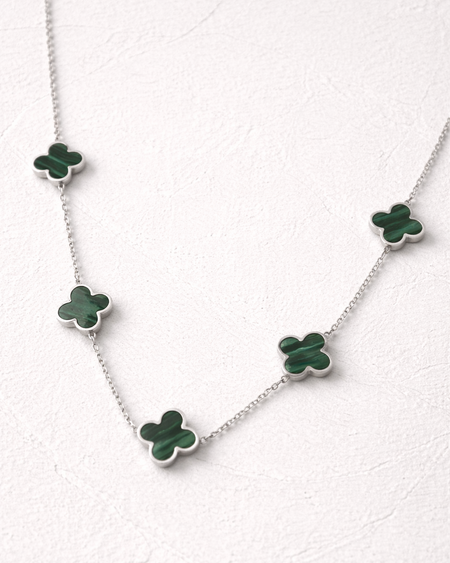 Necklace with green clover-shaped pendants on a white background
