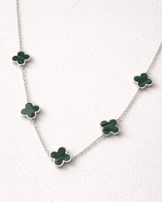 Necklace with green clover-shaped pendants on a white background