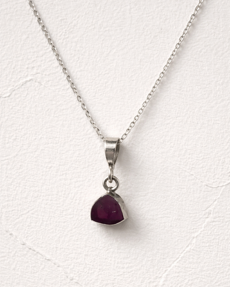 Necklace with a red gemstone pendant on a white background