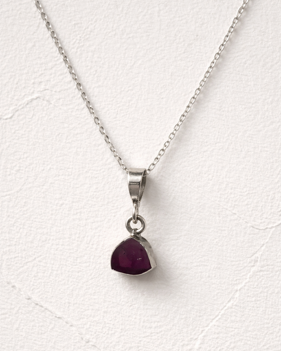 Necklace with a red gemstone pendant on a white background