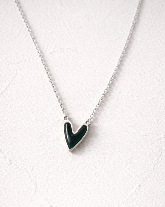 Necklace with a green heart pendant on a white background