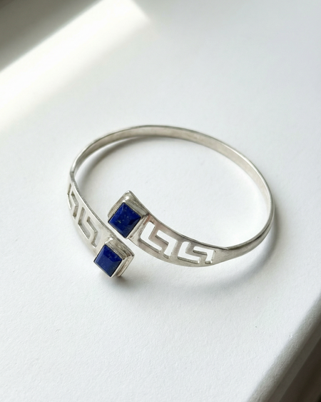 Silver bracelet with blue gemstones on a white background