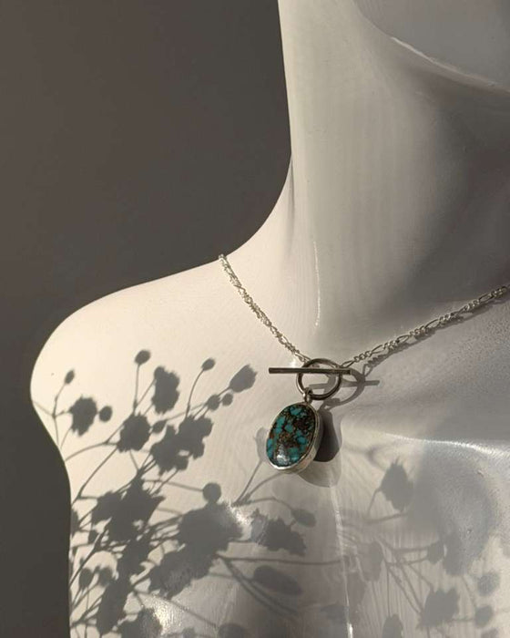 Necklace with a pendant on a mannequin against a dark background
