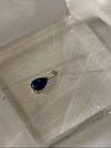 Blue teardrop pendant necklace on a mannequin head with a white background