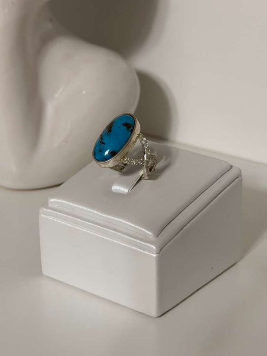 Ring with a blue stone on a white stand