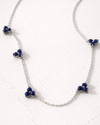Silver necklace with blue beads on a white background