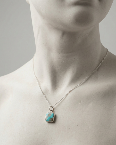 Necklace with a turquoise pendant on a mannequin