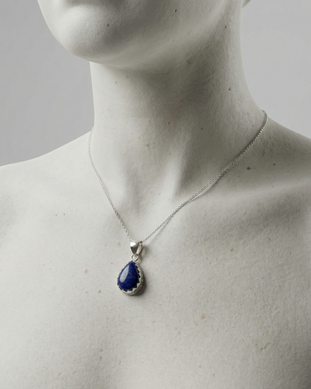 Mannequin wearing a necklace with a blue teardrop pendant