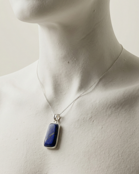 Mannequin wearing a necklace with a blue pendant