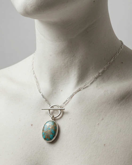 Turquoise pendant necklace on a mannequin with a plain background