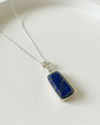 Necklace with a blue stone pendant on a white background