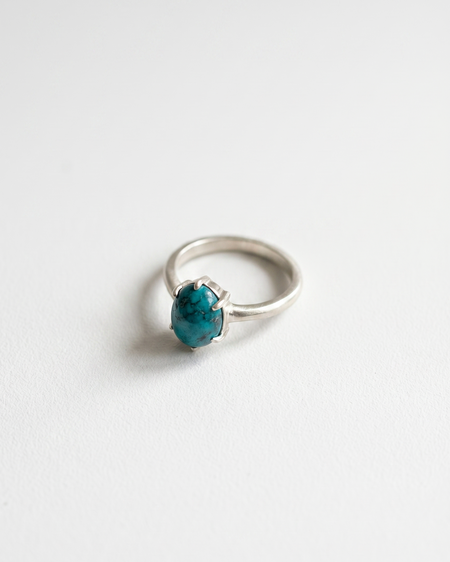 Silver ring with a blue gemstone on a white background