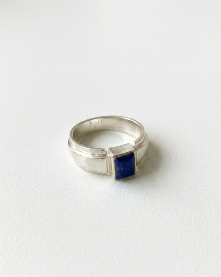 Silver ring with a blue stone on a white background