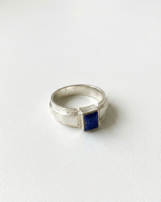 Silver ring with a blue stone on a white background