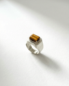 Silver ring with a square brown gemstone on a white background