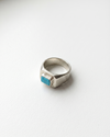 Silver ring with a turquoise stone on a white background