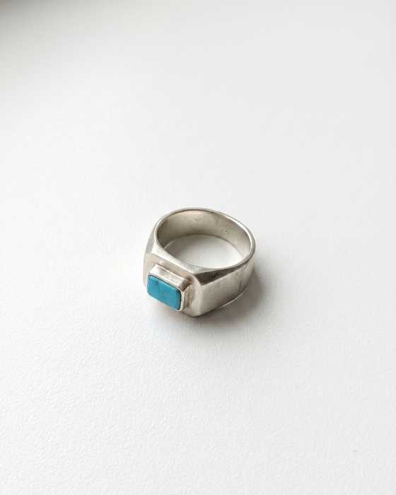 Silver ring with a turquoise stone on a white background